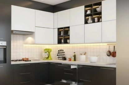 A modern L shaped kitchen with black and white cabinets.