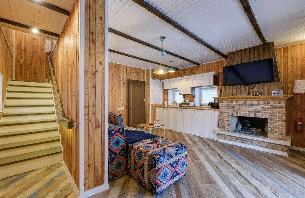 Compact Kitchen Office with wood paneling and a fireplace, perfect for relaxing on a chilly evening.