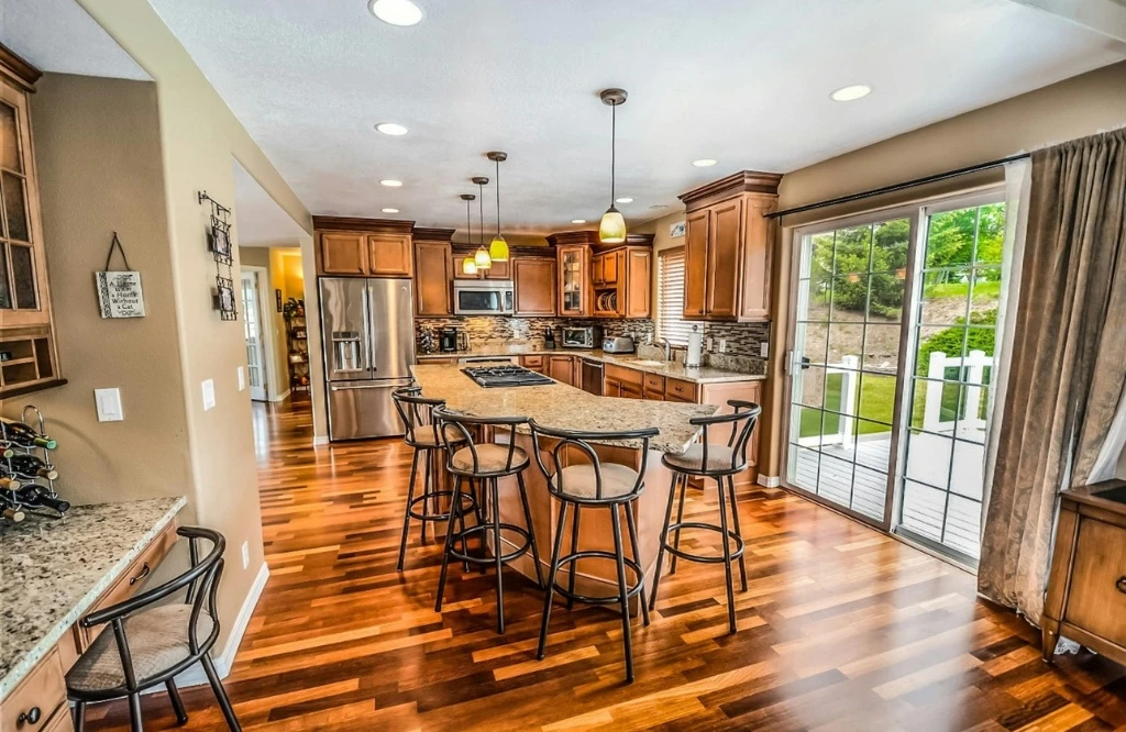 A spacious kitchen with hardwood floors and a large center island.