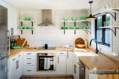 A U-shaped kitchen featuring sleek white cabinets and vibrant green shelves creates a fresh and inviting atmosphere.