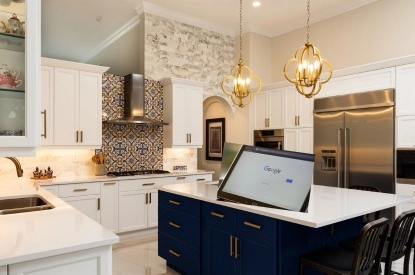 Voice activated kitchen appliance in a kitchen with blue island and white cabinets.