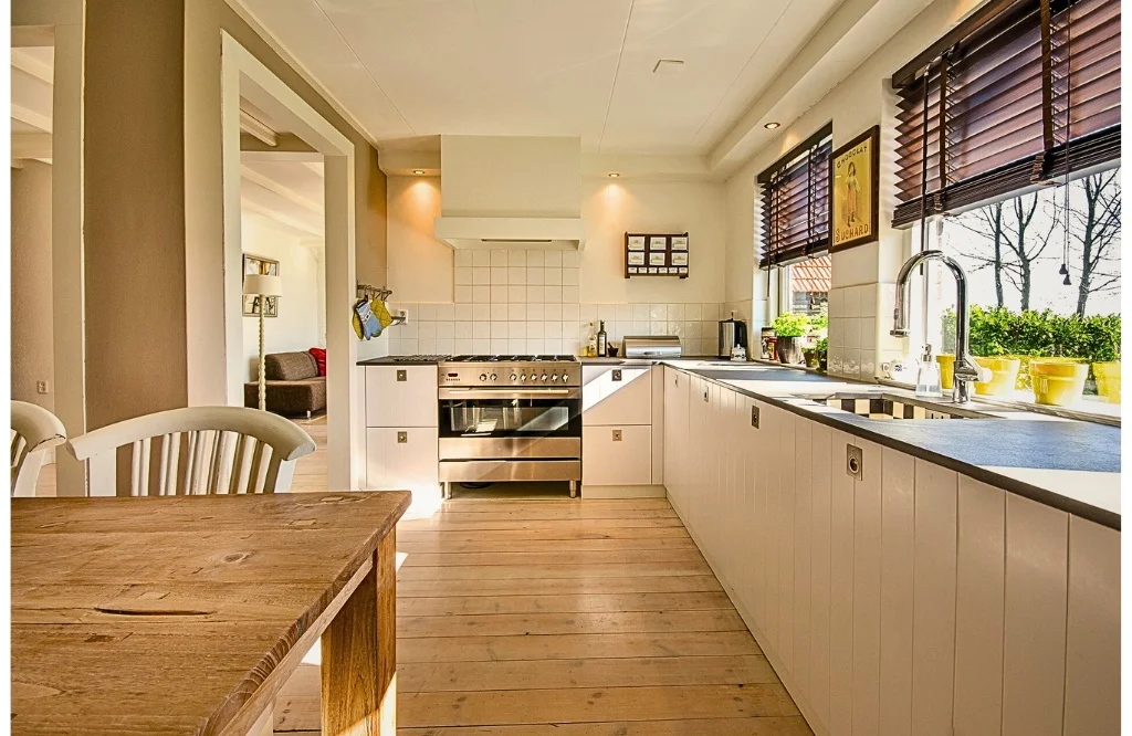 Kitchen with table and chairs in dining areas, featuring an island with kitchen.