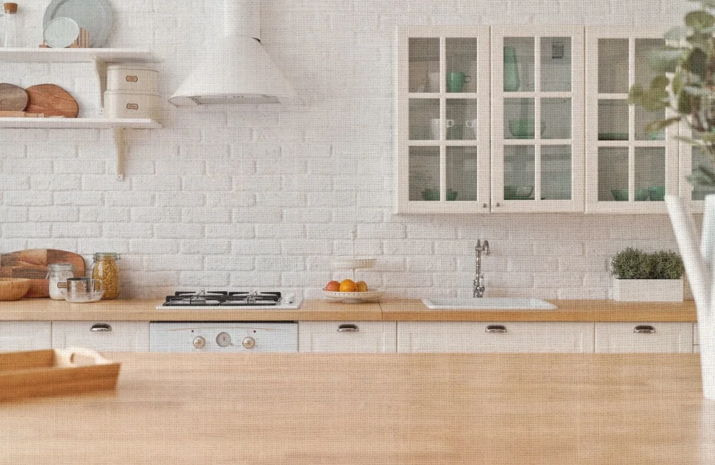 A kitchen featuring white brick walls, wooden countertops, and various textures and fabrics enhancing the overall design.