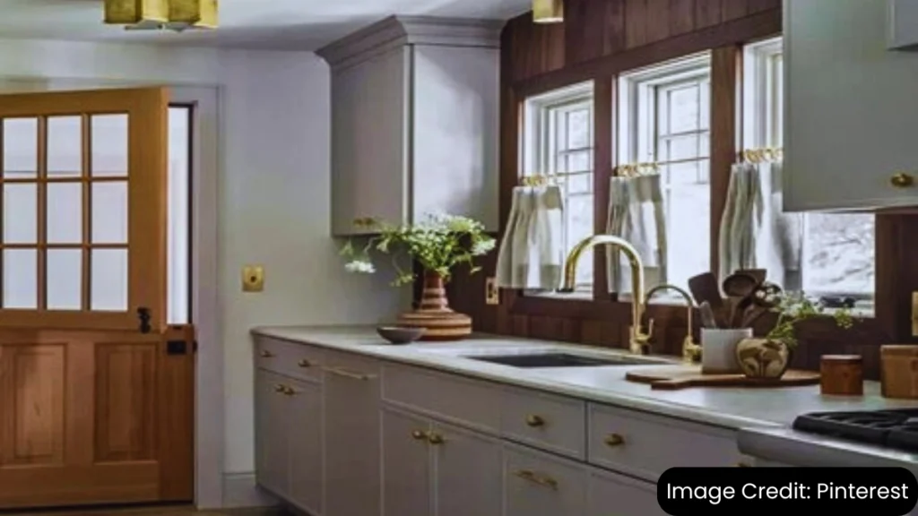 Modern kitchen with gray beadboard cabinets, white countertops, and a wood-paneled wall.