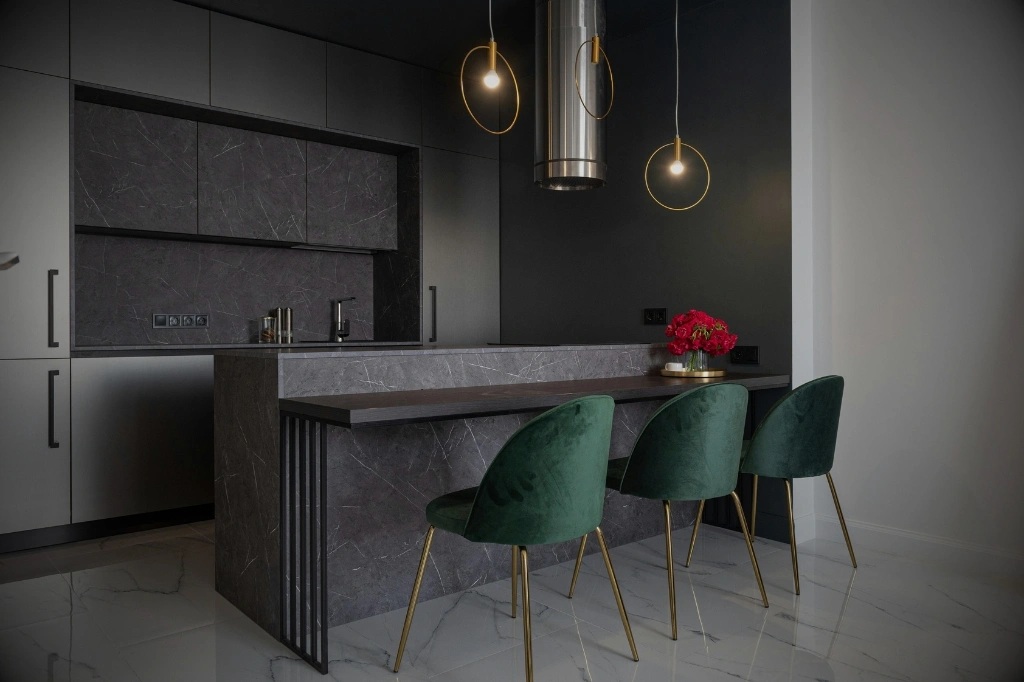 A stylish kitchen with green chairs and a bar showcasing the benefits of a kitchen island for enhanced cooking space.