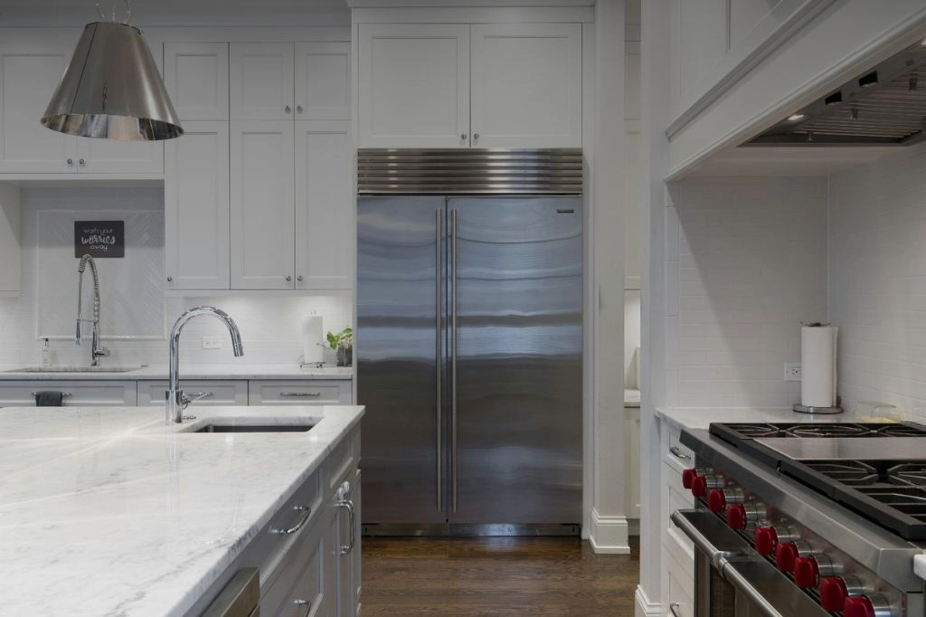 A kitchen featuring cabinets, a stainless steel refrigerator, and a stove highlighting a sleek and efficient design.