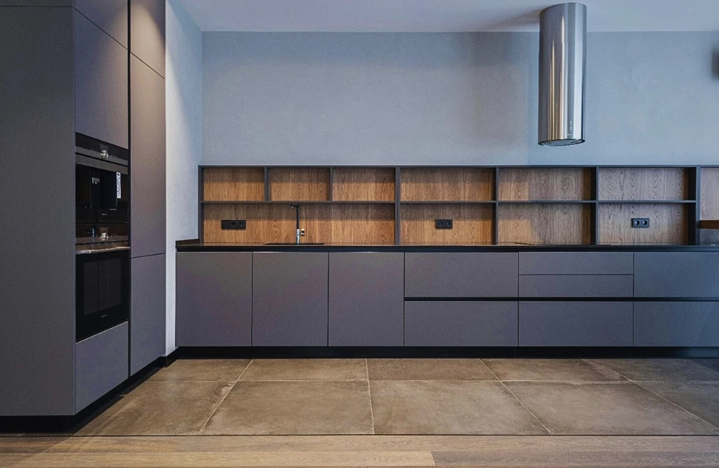 A contemporary kitchen featuring wooden cabinets and a sleek sink, showcasing the latest materials in kitchen cabinetry design.