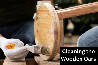 A person carefully cleans a wooden oars, ensuring they shine and are well-maintained.