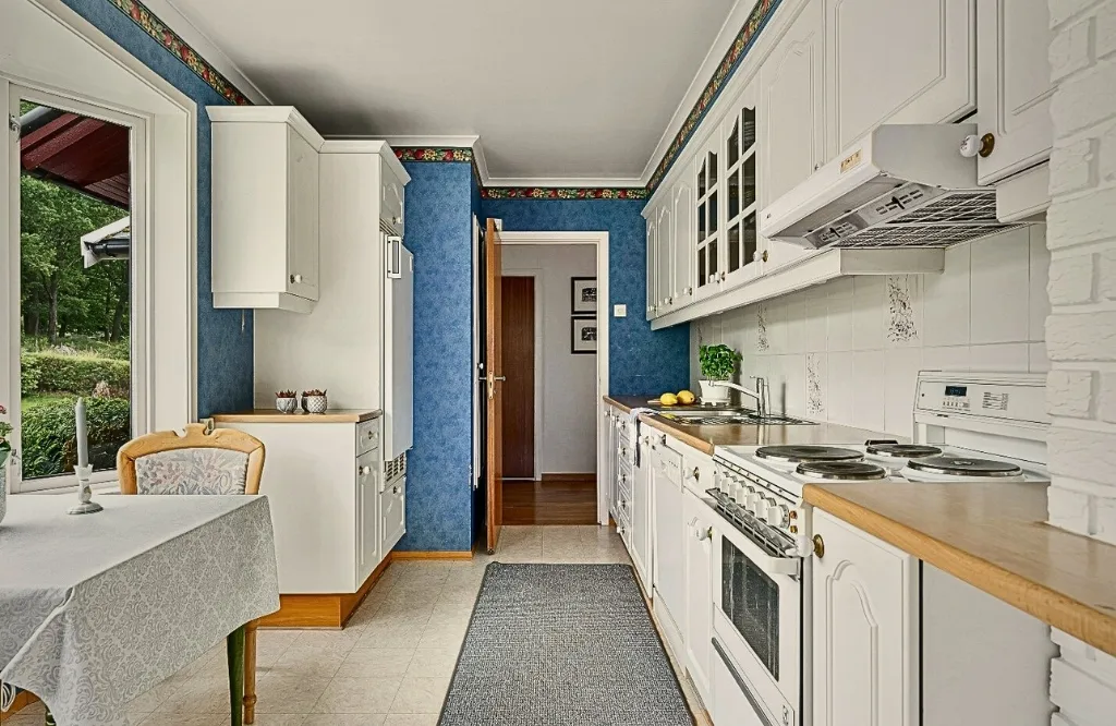 A kitchen featuring a table and chairs, showcasing open shelving alongside traditional cabinets for comparison.