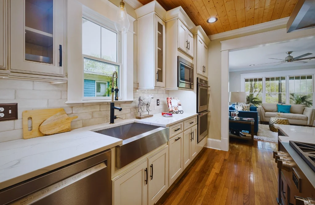 A kitchen featuring a sink, countertop, and various styles of kitchen cabinets for a functional and stylish space.