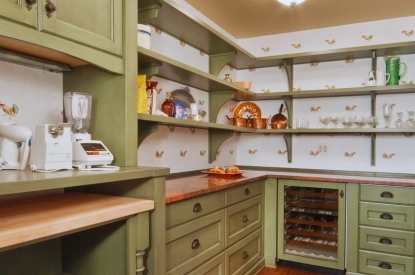 A kitchen featuring earthy green cabinets and a sleek wine cooler, creating a warm and inviting atmosphere.