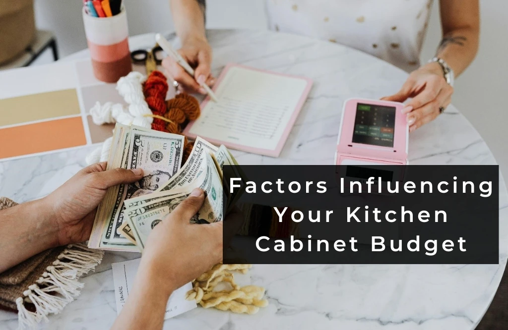 Two individuals at a table, surrounded by money and a pen analyzing the factors that affect their kitchen cabinet budget.