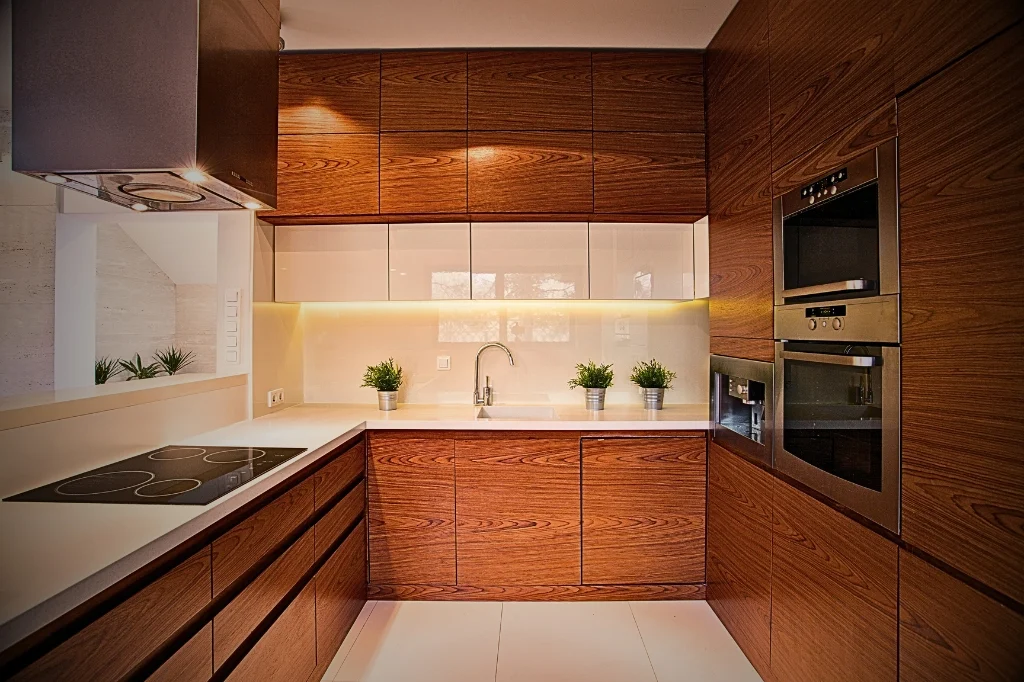 A cozy kitchen with wooden cabinets and a sink reflects the question of how many cabinets does the Average Kitchen Have.