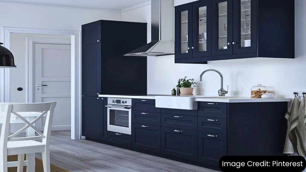 Modern kitchen featuring inset cabinets in a deep blue color with white countertops and glass cabinet doors.