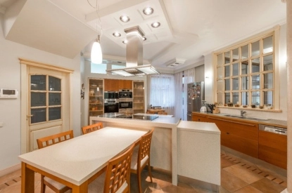 Interior of a kitchen gallery featuring a table, chairs, and a refrigerator.