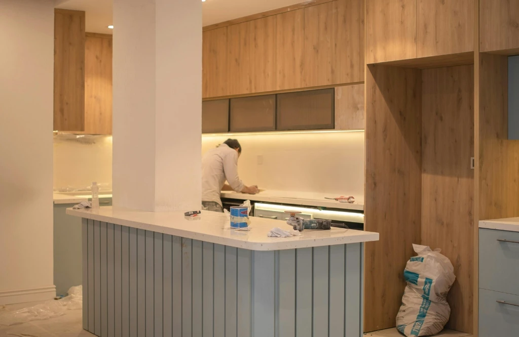 A man diligently working in a modern kitchen, showcasing innovative renovation ideas and design elements.