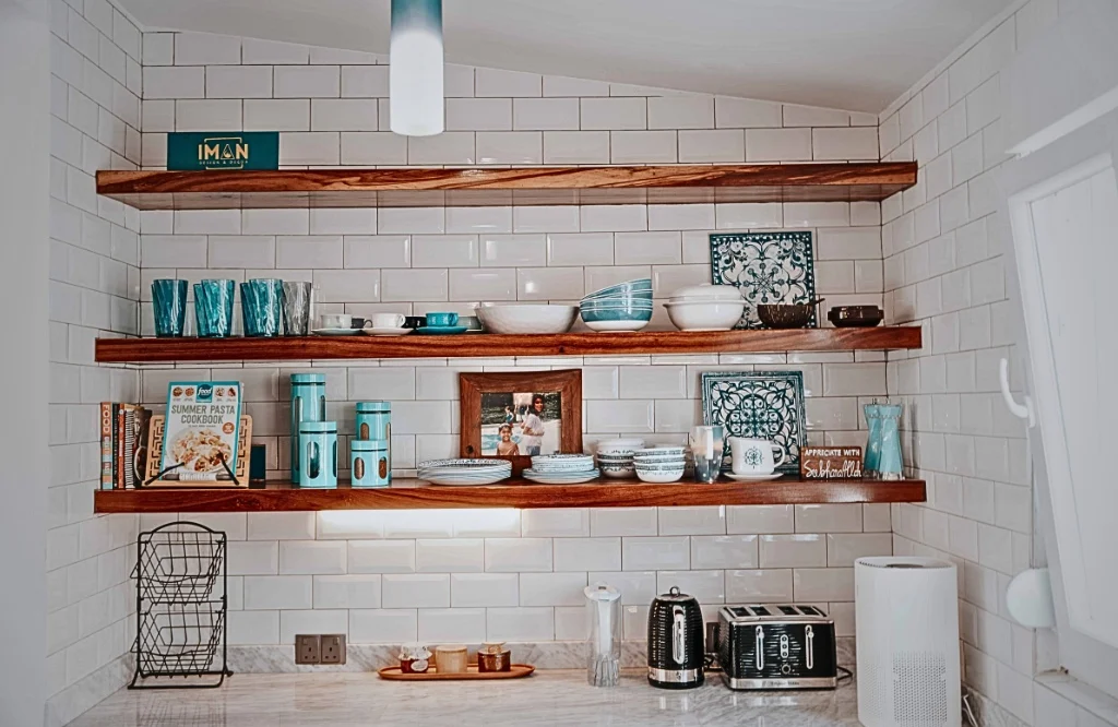 A stylish kitchen with open shelving and blue and white tiles, reflecting a modern aesthetic and organized space.