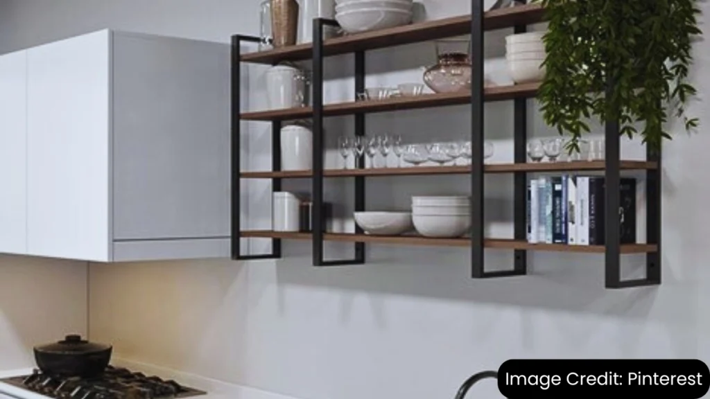 Modern kitchen with open shelving displaying neatly arranged dishware and decor above a black sink.