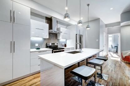 A modern kitchen with white cabinets and appliances, highlighting the quality of recent painting and finishing work.