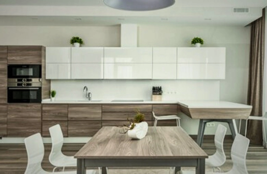 A stylish kitchen with wooden cabinets and white chairs, illustrating the benefits of traditional cabinetry in modern spaces.