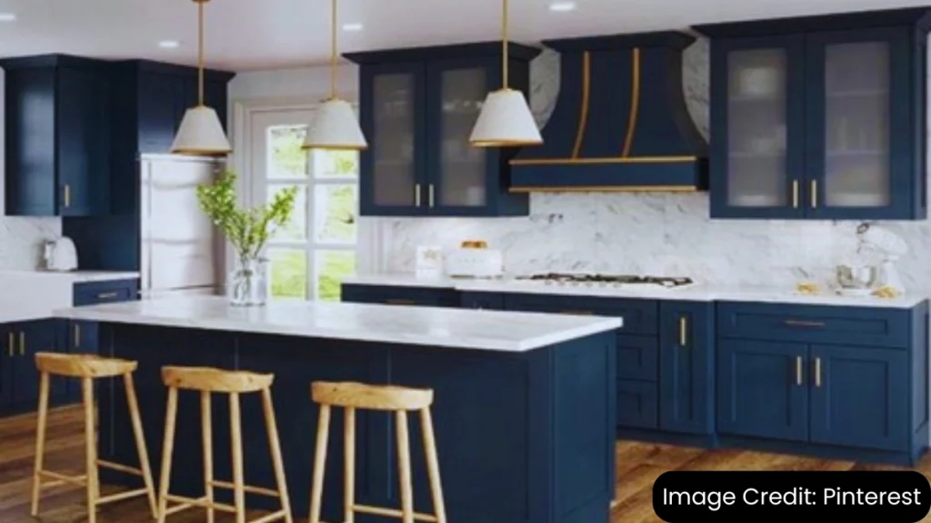 Modern kitchen with navy blue shaker cabinets, marble countertops, and a central kitchen island.