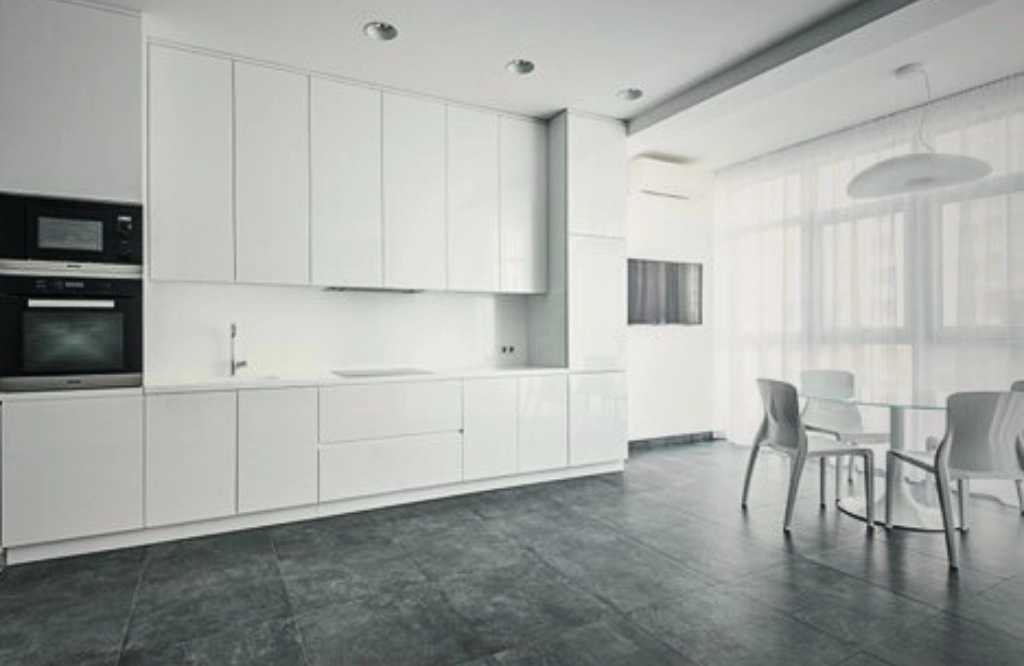  A modern kitchen featuring traditional white cabinets and a stylish dining table, creating a bright and inviting atmosphere.