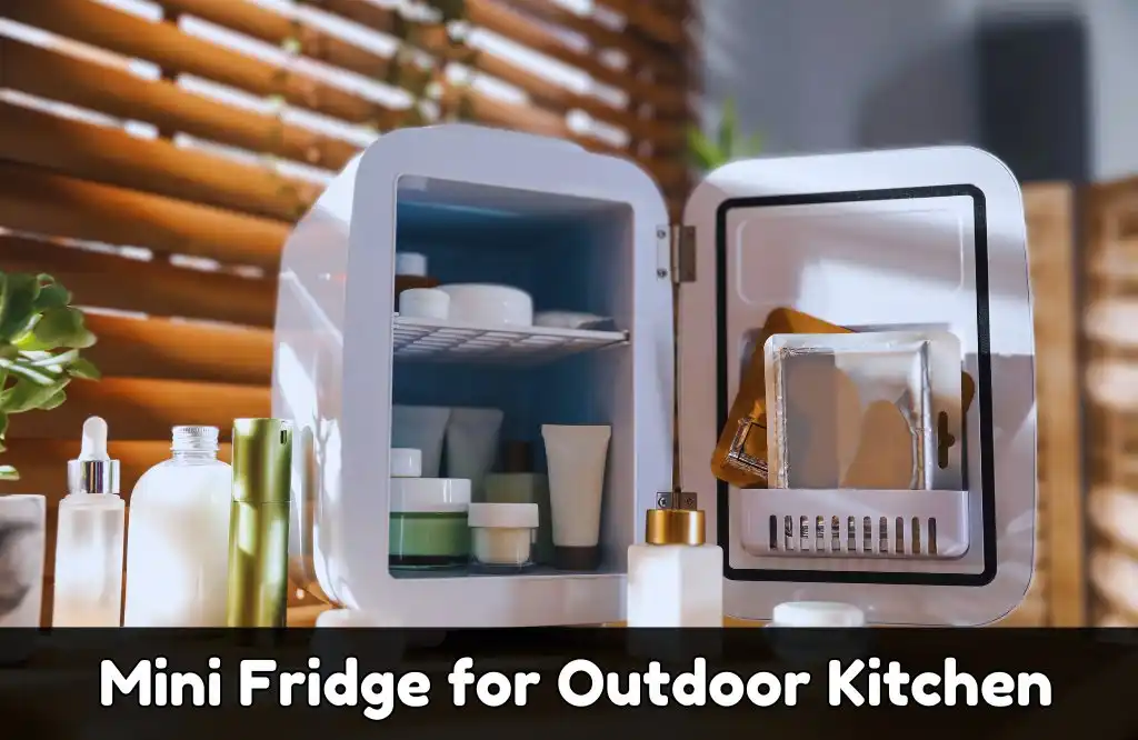 A small white mini fridge with its door open set in an outdoor kitchen with plants and sunlight filtering through wooden blinds.