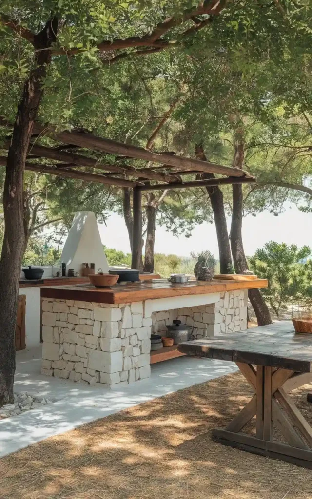 Rustic outdoor kitchen with stone base, wooden countertops, pergola, and natural surroundings, creating a charming and earthy cooking space.