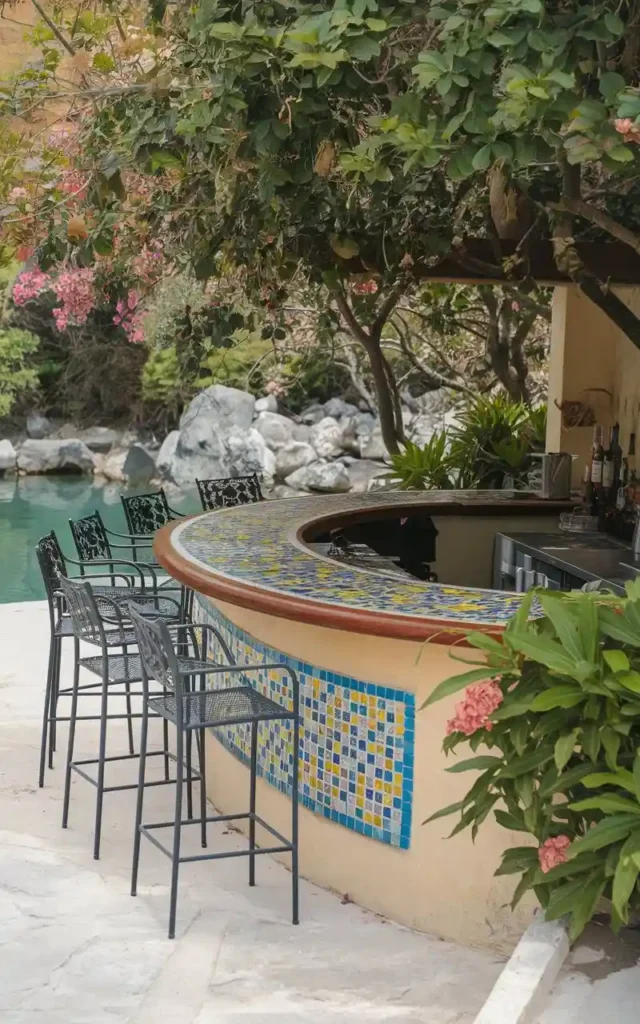 Colorful mosaic bar with tiled designs and outdoor seating surrounded by lush greenery and a serene water feature.