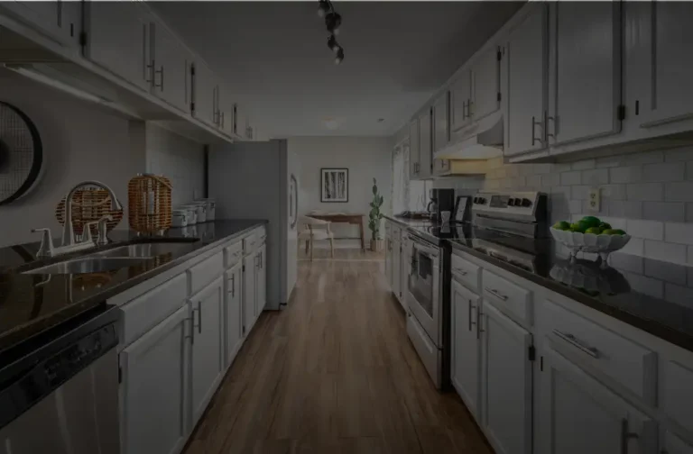 Modern white kitchen with black granite countertops and stainless steel appliances