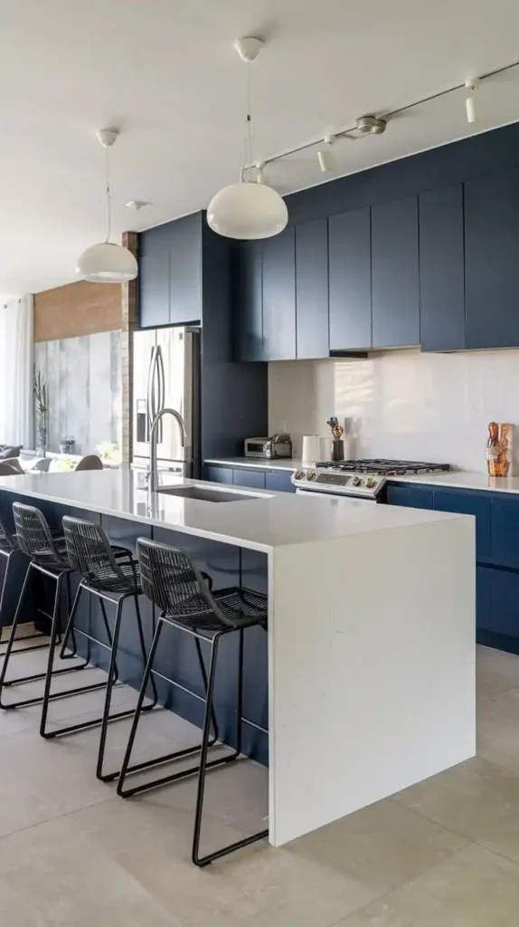 U-shaped kitchen featuring a sleek navy cabinet design with a white waterfall countertop and modern bar seating